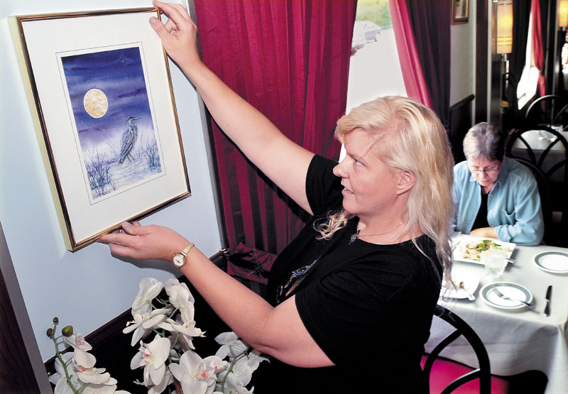 Kiri Guyaz hangs one of her paintings among diners at the M. Thai restaurant in Skowhegan. The venue is one of several taking part in the Wesserunsett Arts Council and Main Street Skowhegan sponsored art walk, beginning this Friday and running through the summer.