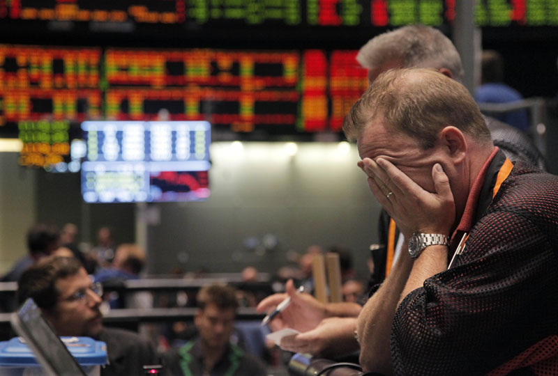 OUCH: Trader Andrew Stavros reacts after the close of trading on the floor of the CME Group on Monday in Chicago. Stocks plunged worldwide Monday on a host of concerns, including Friday's downgrade of the U.S. government's credit rating by Standard & Poor's.