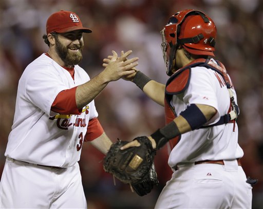 St. Louis Cardinals' Jason Motte (30) celebrates with catcher Yadier Molina after Game 5 of baseball's National League championship series against the Milwaukee Brewers Friday, Oct. 14, 2011, in St. Louis. The Cardinals won 7-1 to take a 3-2 lead in the series. (AP Photo/Matt Slocum)