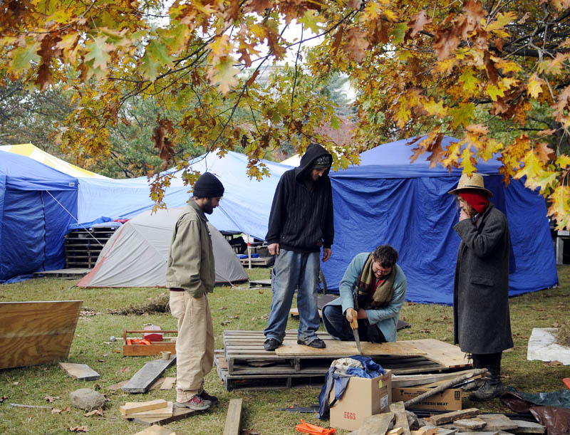 Protesters with Occupy Augusta saw wooden platforms for their tents Monday in Capitol Park in Augusta. Some of the protesters will be attending a forum at the University of Maine at Augusta on Thursday. The group said that the wood will prevent frost from heaving their tents as the occupancy enters its second week.