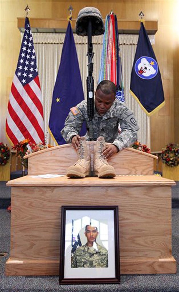 In a Thursday morning, Oct. 20, 2011 file photo, Sgt. 1st Class Bobby Gates straightens the combat boots on a display before a memorial service for Pvt. Danny Chen of the 3rd Battalion, 21st Infantry Regiment at the Southern Lights Chapel on Fort Wainwright in Fairbanks, Alaska. (AP Photo/Fairbanks Daily News-Miner, Eric Engman, File)