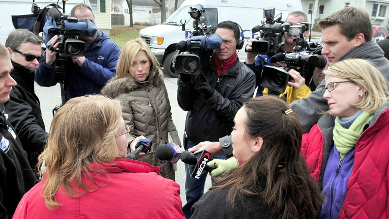 COVERED: Local, state, and regional media representatives interview Amy Taylor, left front, and Mirisha Lawler on Monday near the home on Violette Avenue in Waterville, where Ayla Reynolds was reported missing Friday. The women said they were on their lunch break and wanted to assist in the search effort for the 20-month-old girl.