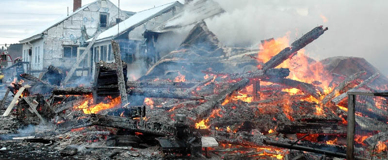 Staff photo by Doug Harlow Firefighters from several towns battled a blaze Thursday morning on Brighton Road, Route 151, that destroyed a large barn and part of the adjoining farm house. The residents said they were insured.