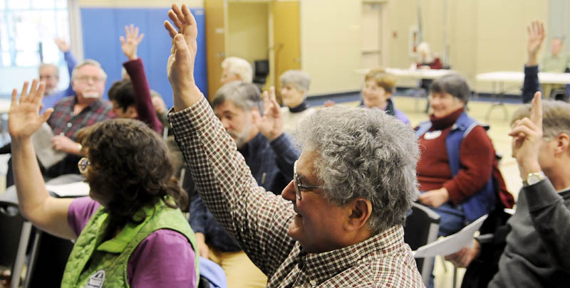 Democrats vote on a measure Sunday during a caucus held in Gardiner. Democrats in communities across Maine met to hear candidates, sign petitions and mobilize for the upcoming elections in 2012.