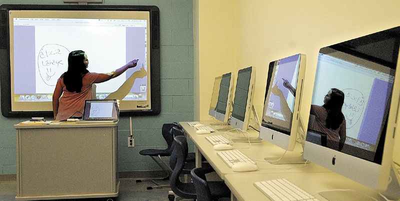 Chelsea Elementary School student Alicia Lahaye is reflected in several iMacs as she demonstrates an interactive white board during a an open house on Thursday night at the new Chelsea Elementary School.