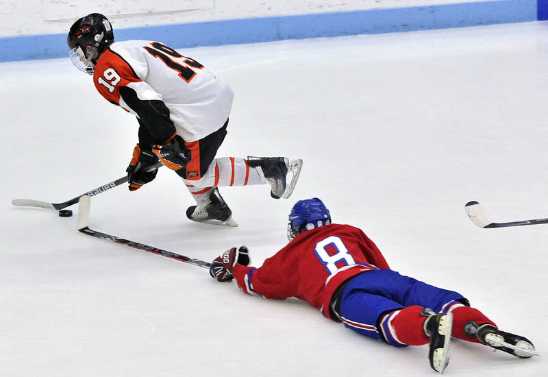 Photo by Michael G. Seamans Messalonskee High School's William Blake, 8, dives for Brewer High School's Kyle Alexander, 19, in the first period of the Class B East hockey regional finals at Alfond Arena at the University of Maine in Orono Tuesday night.