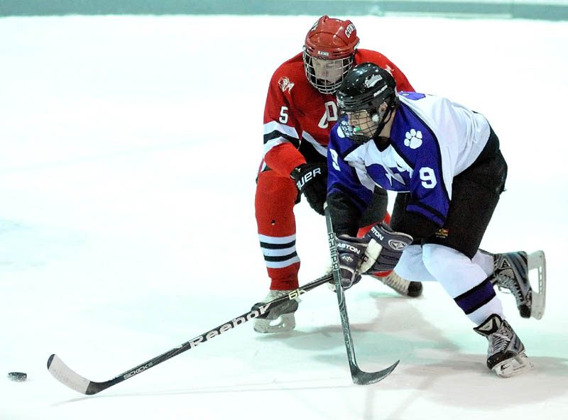 Waterville Senior High School’s J.T. Whitten (9) battles for the puck with Cony High School’s Spencer Buck. Whitten was named a Travis Roy semifinalist as one of the best Class A senior boys hockey players in Maine.