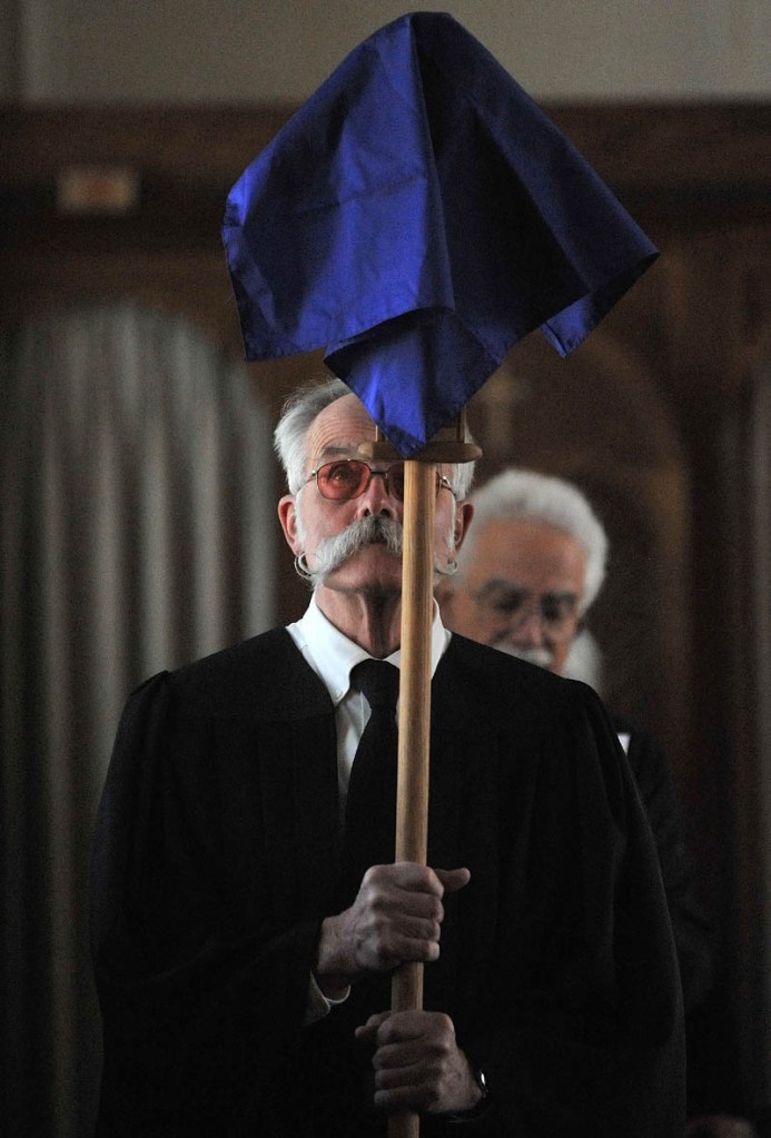 Staff Photo by Michael G. Seamans Richard Spear and others with the Holy Trinity Anglican Church mark Good Friday and the crucifixation of Jesus Christ during a service in Waterville. The Friday service precedes Easter, which celebrates Christ’s resurrection on the third day after his death. The Anglican church group rents space at Sacred Heart Church for their services.