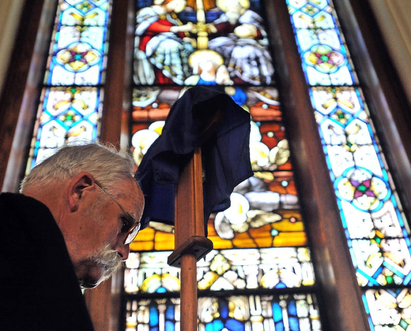 Staff Photo by Michael G. Seamans Richard Spear and others with the Holy Trinity Anglican Church mark Good Friday and the crucifixation of Jesus Christ during a service in Waterville. The Friday service precedes Easter, which celebrates Christ’s resurrection on the third day after his death. The Anglican church group rents space at Sacred Heart Church for their services.