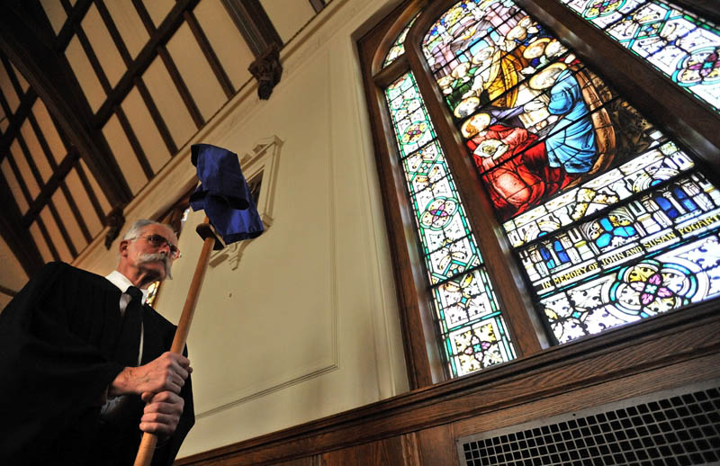 Staff Photo by Michael G. Seamans Richard Spear and others with the Holy Trinity Anglican Church mark Good Friday and the crucifixation of Jesus Christ during a service in Waterville. The Friday service precedes Easter, which celebrates Christ�s resurrection on the third day after his death. The Anglican church group rents space at Sacred Heart Church for their services.