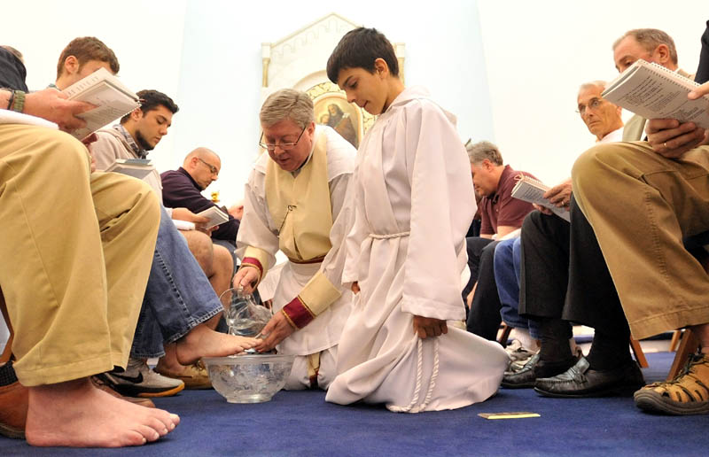 Staff Photo by Michael G. Seamans Father Larry Jensen washes the feet of 12 parishioners during the Holy Thursday service at St. Joseph's Maronite Church in Waterville Thursday evening. In the Holy Thursday service, Father Larry Jensen washed the feet of some parishiners as did Jesus and his disciples before the Last Supper.