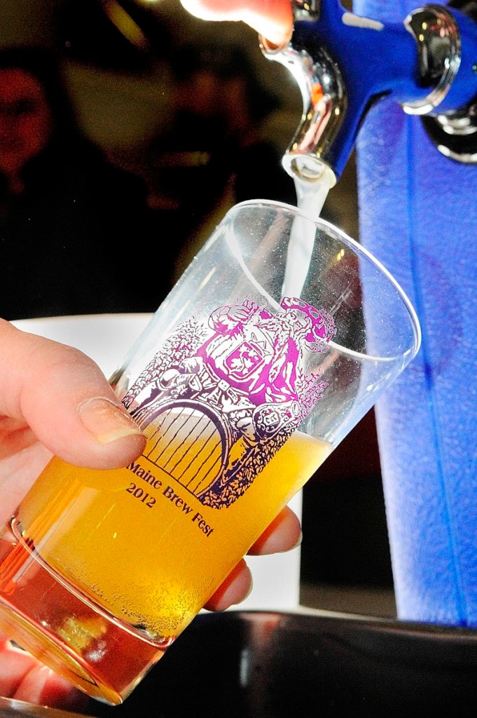 JUST A TASTE: Dorothy Sullivan pours a 4-ounce sample of hard cider at the Downeast Cider House booth during the Central Maine Brew Fest on Saturday at Augusta Armory. The Downeast Cider House is located in Waterville.