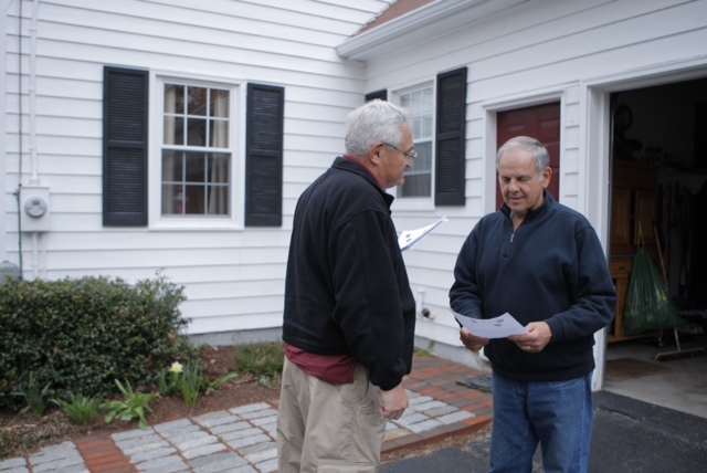 Don Klemanski, with the Cumberland County Volunteers in Police Service, hands out a flier to Dick Capozza at his home on White Rock Road in Gorham this evening. Volunteers handed out fliers in various neighborhoods and asked residents to be extra vigilant and report any suspicious activity.