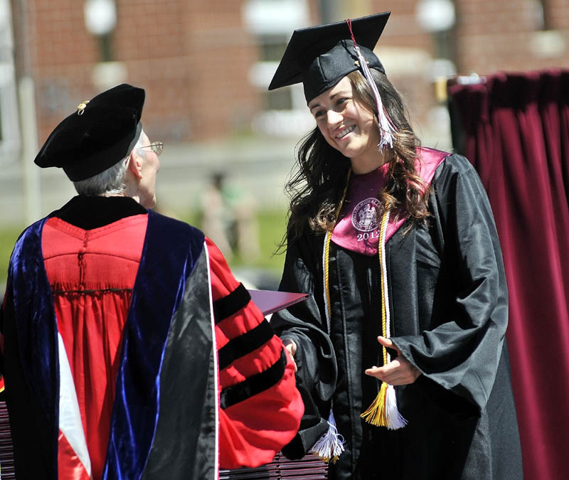 Staff Photo by Michael G. Seamans Kelly Greene receives her diploma from President Theodora Kalikow during Commencement ceremonies at University of Maine at Farmington Saturday.