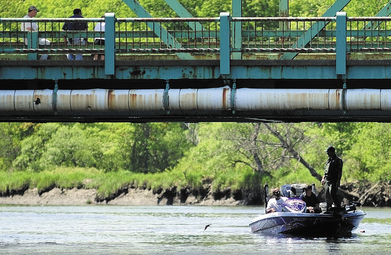 People on the Route 24 bridge watch as one of the search boats returns to Philip Mailly Waterfront Park in Bowdoinham as the search for Santana Dubon, 32, of Portland continued Sunday. His body was found later in the day.