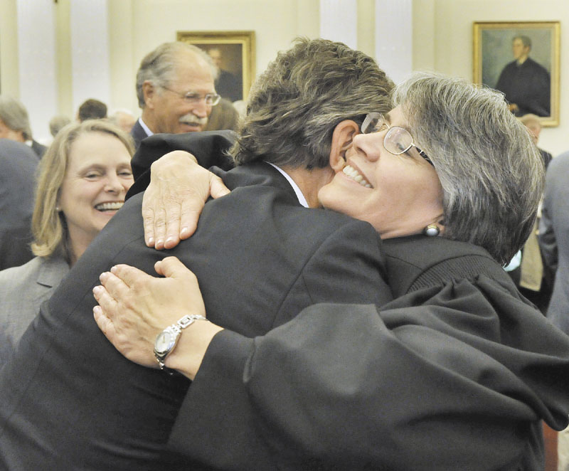 Judge Nancy Torresen shares a hug with longtime friend Don Hawkes, of Bangor, following an Investiture ceremony for her to the U.S. District Court in Portland’s Federal Courthouse.