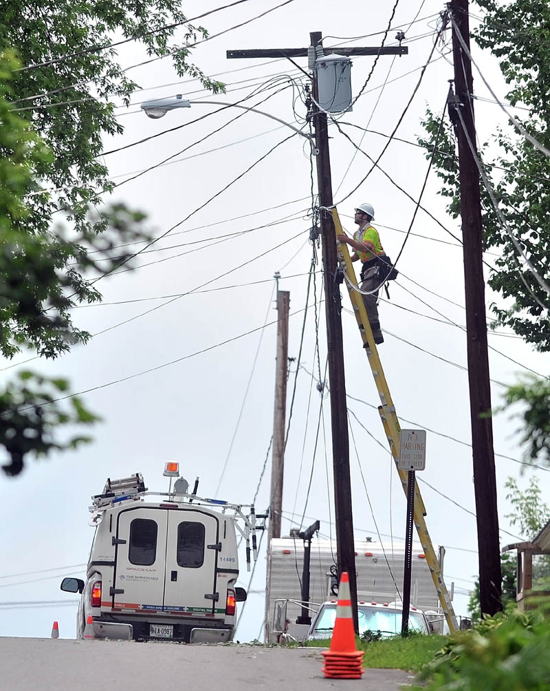 Staff Photo by Michael G. Seamans A line worker with Time Warner Cable restores connections to customers on Abbott Street in Waterville on Saturday. Abbott Street was one of the hardest hit by Friday's storm.