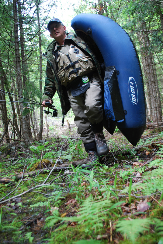 Jerry Derosier hikes in a quarter-mile from the road to Mud Pond in Embden to survey it for the state. Derosier is one of the volunteers who are helping the state on its brook trout pond survey.