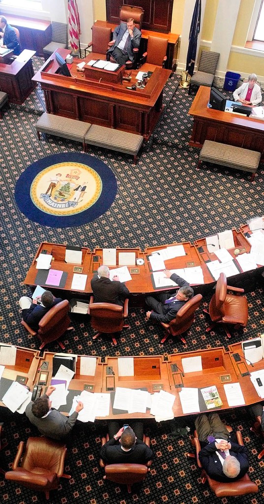 Sen. Justin Alfond, D-Portland, bottom left, speaks during a debate on overriding Gov. Paul LePage’s veto of a teacher training bill on Thursday in Augusta. That was the only one of four vetoes ultimately overturned by the Legislature.