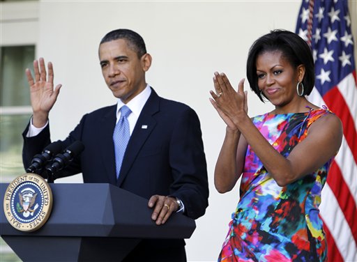 ADVANCE FOR SUNDAY, AUG. 19 AND THEREAFTER - FILE - In this May 5, 2010, file photo, President Barack Obama and first lady Michelle Obama attend a celebration of Cinco de Mayo in the Rose Garden of the White House in Washington. She is 5-foot-11, and she is world-famous. Sometimes she inspires awe in her admirers. She has been accused of being the angry type. So when Michelle Obama meets people, she likes to bring things down to earth with a hug. (AP Photo/Charles Dharapak, File)