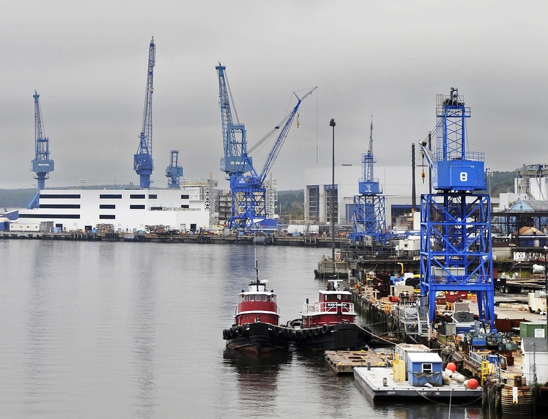 Cranes tower over Bath Iron Works on the Kennebec River waterfront. The Bath shipyard, with 5,400 employees, continues to receive contracts to build warships, but a slowing U.S. Navy production schedule has contributed to layoffs.