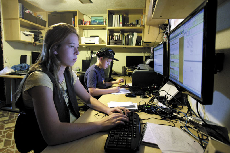 In this photo taken Dec. 13, 2011, Celestial McBride, left, 14, and her brother Sevan, 12, work on an online classes from the Florida Virtual School from their home in Mims, Fla.