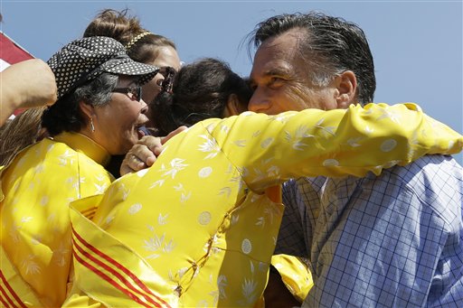 Republican presidential candidate Mitt Romney embraces women wearing traditional Vietnamese "ao dai" dresses as he campaigns at Van Dyck Park in Fairfax, Va., on Thursday.