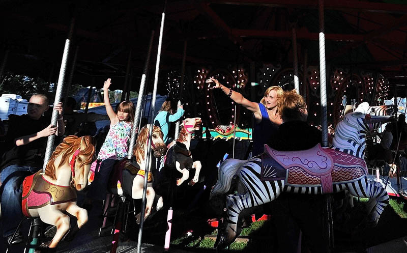 People wave to their friends and family as the Merry-go-Round spins at the Farmington Fair Wednesday afternoon. The fair runs through Saturday Sept. 22.