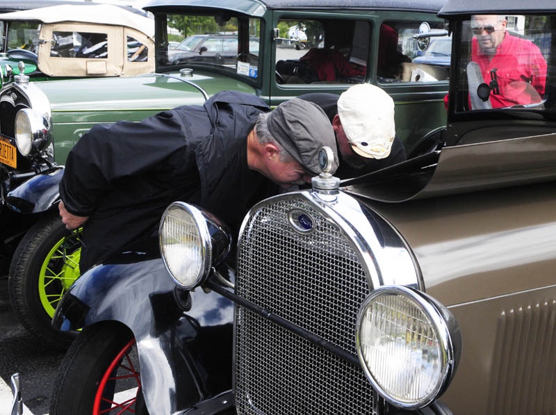 Staff photo by Joe Phelan Joe Farina, left, and Mark Hoffman look under the hood of Hoffman's 1929 Model A, that he and his father Kenneth Hoffman fixed up, on Wednesday morning at Mulligan's in Manchester. The men were part of a group of five old Model A Ford owners that were going from the Albany New York area to an event this weekend in Rockport.