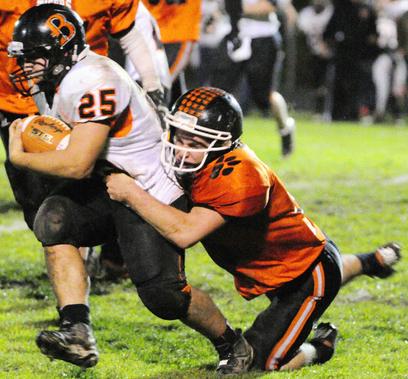 Brewer running back Dillon Smith, left, is dragged down by Gardiner defensive back Dennis Meehan during a game on Friday night at Hoch Field in Gardiner.