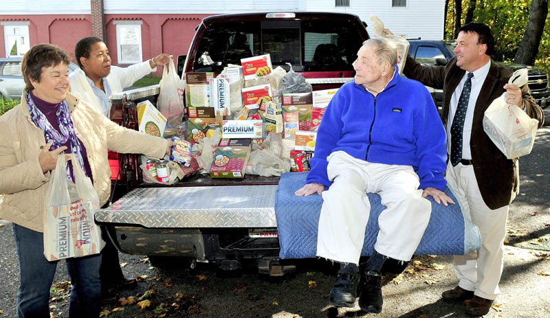 Charlie Breton, on truck, watches as his daughter Carol Mckinnon, left, Rev. Effie McClain and son Alan Breton deliver $500 worth of food to the Oakland Area Food Pantry in Oakland on Wednesday. Charlie Breton's cousin Georgette Desmond suggested guests donate food rather than gifts during Breton's recent 94th birthday party. "It's a much needed food donation," McClain said.