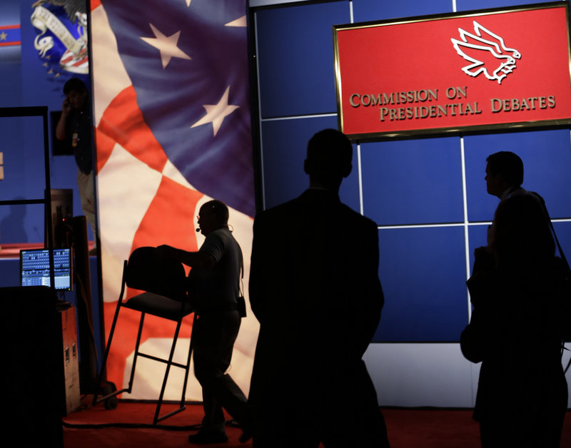 Workers prepare the set for Wednesday night’s presidential debate, the first of three, at the Magness Arena on the campus of the University of Denver. The debate is scheduled to start just after 9 p.m.