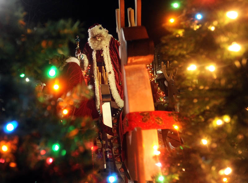 Santa Claus stands on top of his float, at Kringleville in Castonguay Square in downtown Waterville, Friday night, during the annual Parade of Lights.