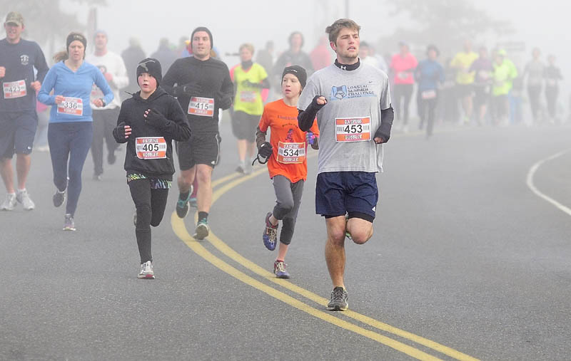 Runners round a bend on Pierce Drive during the Gasping Gobbler 5K race on Thursday morning that started and ended at Cony High School in Augusta. There were over 400 finishers in the annual Thanksgiving day race that gave food for prizes. The first male and female finisher got a trophy and full Thanksgiving dinner. In the each age group, the prizes were a turkey for first place, pie for second place and then dinner rolls for third.