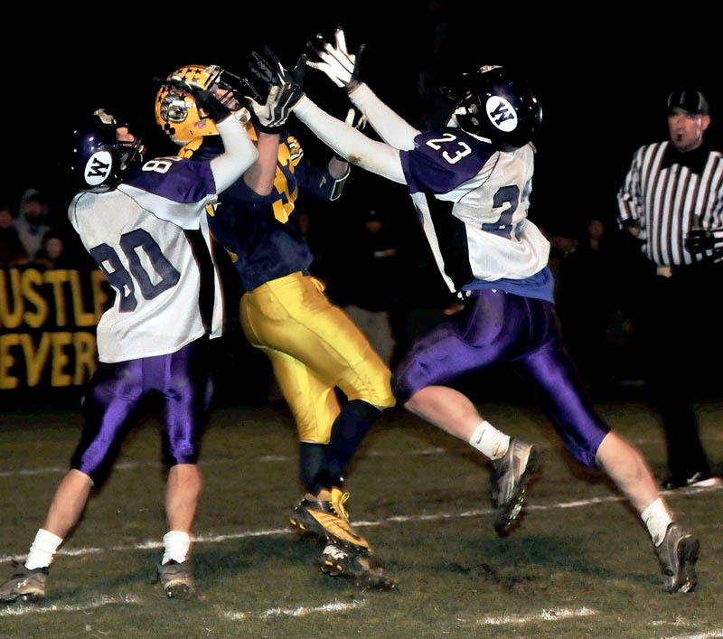 Staff photo by David Leaming Mt. Blue's Nick Hyde reaches for throw as Waterville's Devin Burgess, left, and Jordan DeRosby pressure during game on Friday in Farmington.