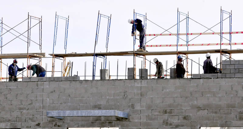 Workers lay cement blocks on the ongoing expansion projects at Mt. Blue High School in Farmington on Wednesday.