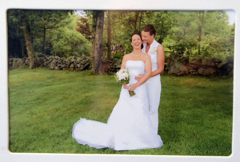 Alissa Poisson and Maggie Oechslie of South Portland in a family photo on display in their home from June of 2011 when they had a commitment ceremony in Cape Neddick.