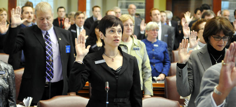 Gay Grant, D-South Gardiner, center, takes the oath of office Wednesday Dec. 5, as a State Representative at the House in Augusta.