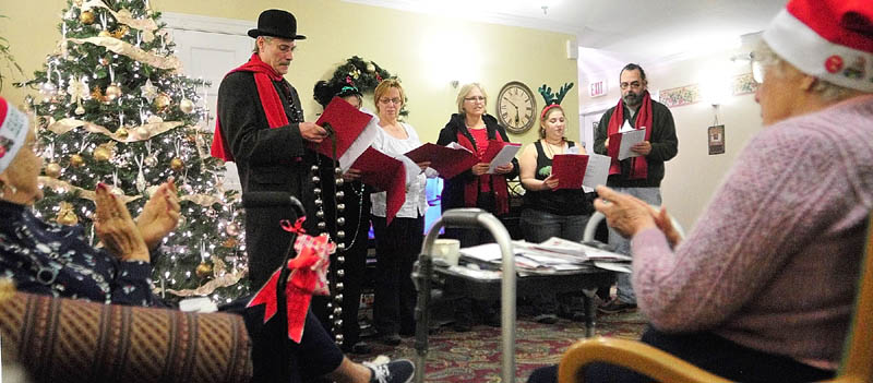 Connie Wing, left, and Eunice Dee clap for the Cosmic Carolers after they finished a song at the Hillside Terrace on Wednesday, in Hallowell. The group performs in the city's annual Christmas parade and this is the eigth year that the Cosmic Carolers have performed at several assisted-living and nursing homes in Hallowell.