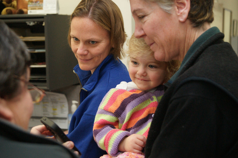 Becky Roak, left, and Mary Parker get their marriage license Saturday at Brunswick Town Hall. They’re accompanied by their 22-month-old daughter, Grace.