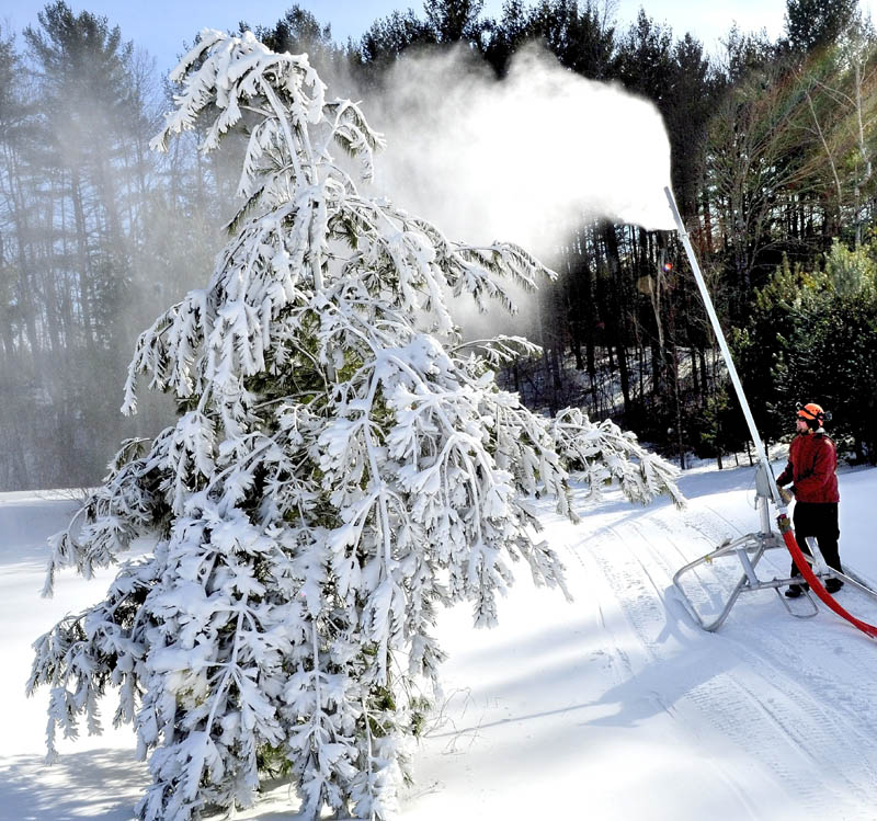 Tim Norton of J.R. Fabrication Co. makes adjustments to some of the new snow-making equipment on trails at the Quarry Road Recreation Area in Waterville Monday.