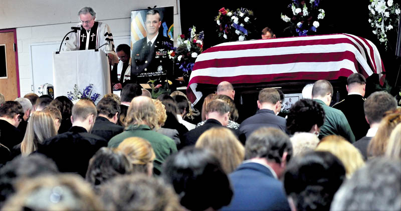 The Rev. David Smith leads a prayer during a funeral service on Sunday for Lt. Col. Michael Backus, 44, of Wilton, who died unexpectedly on Jan. 7 at Camp Keyes in Augusta. The service was held at the University of Maine in Farmington before an overflow crowd of family, friends and service members.