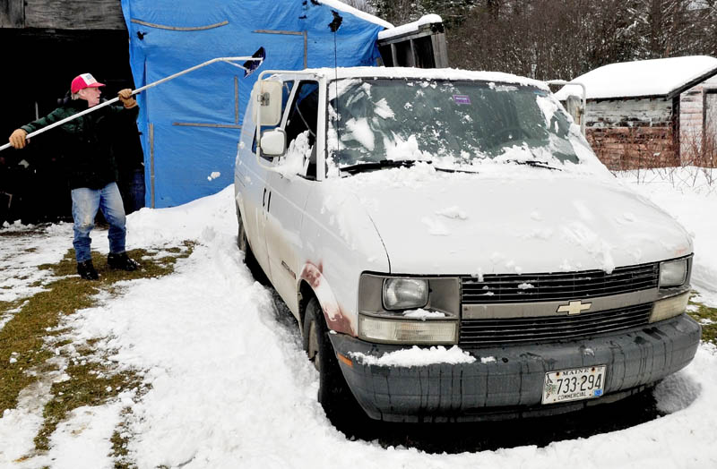 Larry Andersen uses a roof rake to reach the snow that has accumulated on his van in Cornville on Thursday, Jan. 17. 2013.