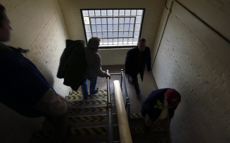 State lawmakers walk from one building to another at the Maine Correctional Center in Windham, a sprawling complex of more than a dozen buildings, during a tour of the facility Friday.