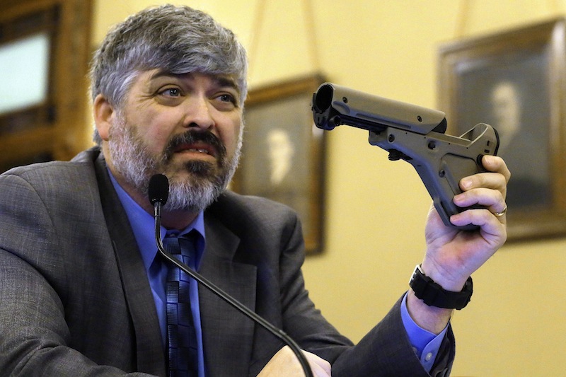 Todd Vandermyde, with the NRA, shows off a gun butt stock during a House Committee hearing on assault weapons at the Illinois State Capitol Thursday, Feb. 28, 2013, in Springfield Ill. Members of the Illinois House and advocates on both sides of the gun issue are debating whether civilians need to be armed with military-style assault rifles. The House Judiciary Committee had its third gun hearing in two weeks on Thursday.