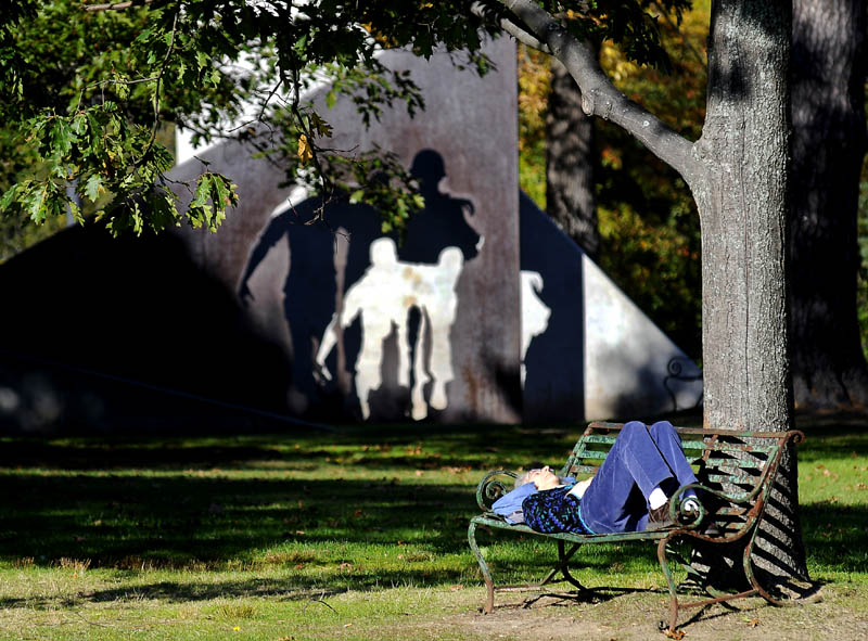 Deb Robbins, of Palmyra, grabs some sun Oct. 12, 2010, on a bench at Capitol Park in Augusta. A proposal to have edible plants added to Capitol Park's horticultural offerings had a public hearing at the State House on Monday.