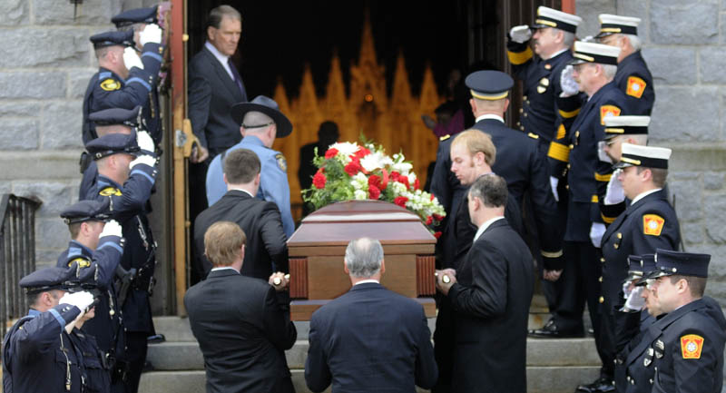 Gardiner police, left, and firefighters salute as the remains of William MacDonald are carried into funeral services Tuesday at St. Joseph's Catholic Church in Gardiner. MacDonald was Gardiner's commissioner of public safety, a joint of position of police and fire chief, from 1959 to 1979, then was elected mayor in the early 1980s. MacDonald died Wednesday in Gardiner, where he was born 88 years ago. He is survived by his wife of 60 years, Christine MacDonald, and several generations of children and grandchildren.