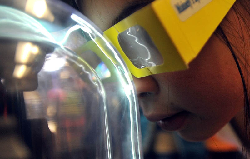 Alexis West, 10, plants her nose on the plasma ball in the first Science, Technology, Engineering and Math Day at Albert S. Hall School in Waterville on Friday.