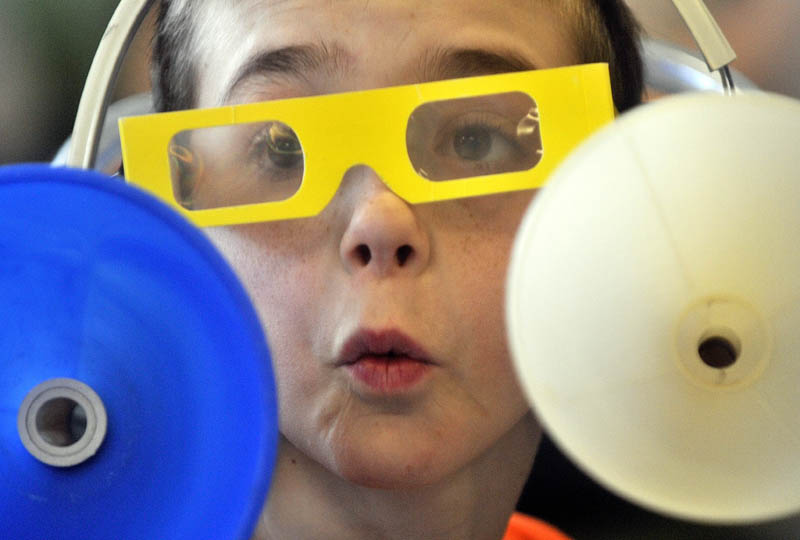 Chase Perkins, 11, reacts after listening to a variety of sounds in his sound amplification head set during the physics lessons in the first Science, Technology, Engineering and Math Day at Albert S. Hall School in Waterville on Friday.