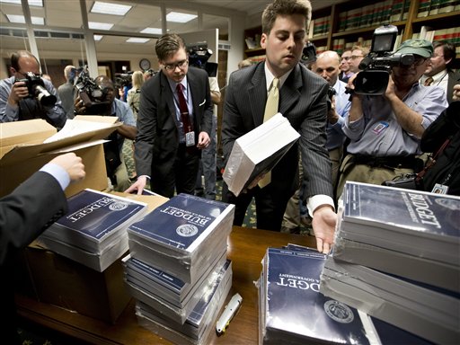 Copies of President Barack Obama's budget plan for fiscal year 2014 are distributed to Senate staff on Capitol Hill in Washington, Wednesday, April 10, 2013. The president sent Congress a $3.77 trillion spending blueprint that seeks to tame runaway deficits by raising taxes further on the wealthy and trimming popular benefit programs but has drawn angry responses from both the right and left. (AP Photo/J. Scott Applewhite)